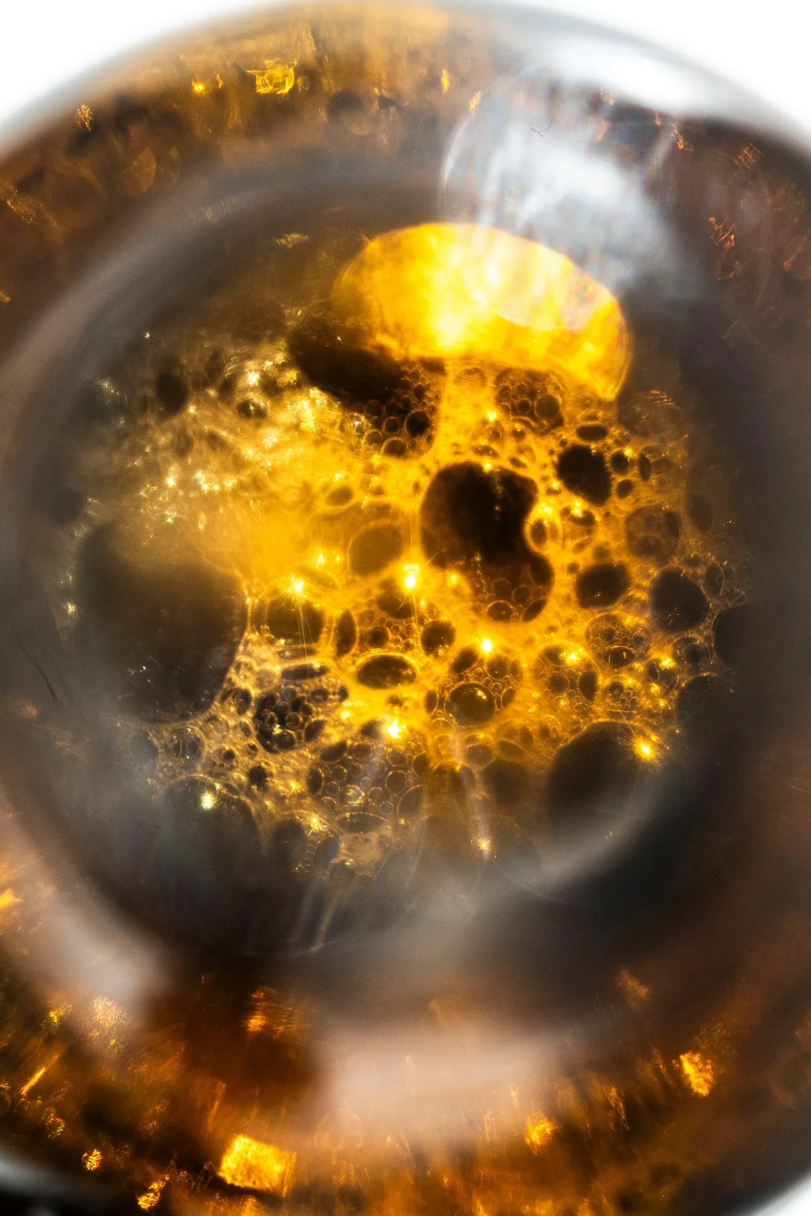 Macro of amber citrus oil with glowing bubbles