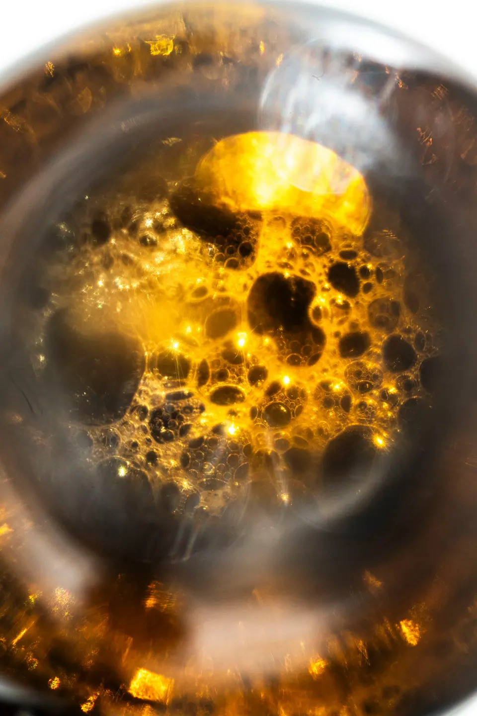 Macro of amber citrus oil with glowing bubbles